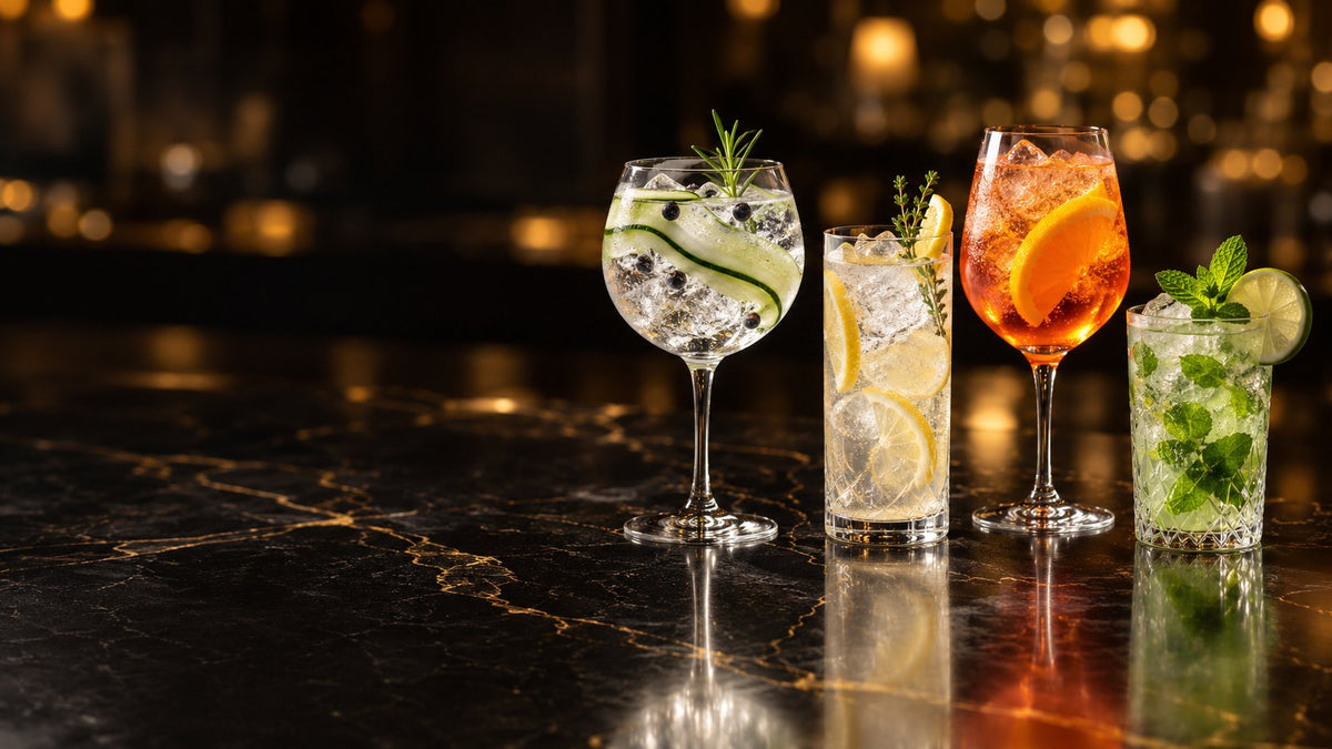 Cuatro cócteles sin alcohol con cítricos, pepino y hierbabuena sobre una barra de mármol negro