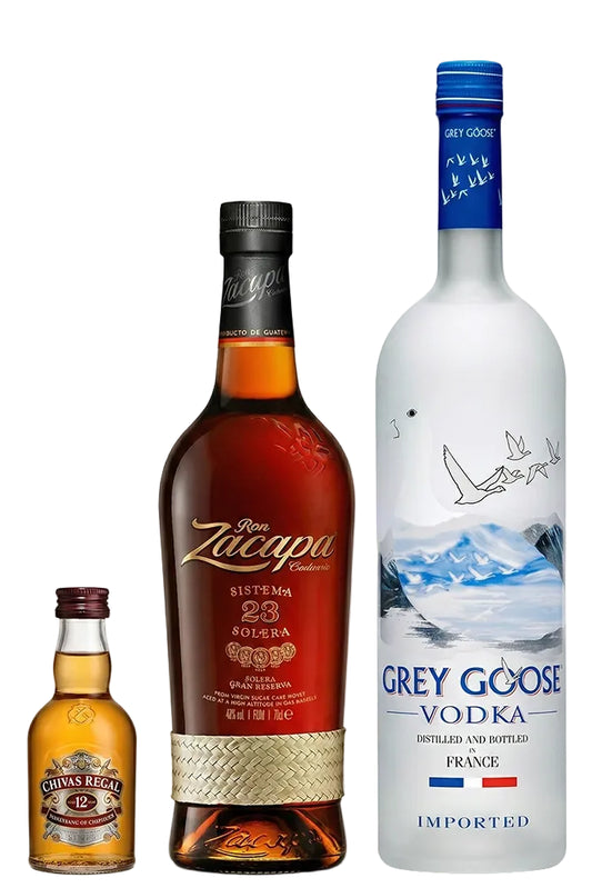 Botellas de Ron Zacapa 23 y Vodka Grey Goose de 1 litro junto a miniatura de Chivas 12 sobre fondo blanco.