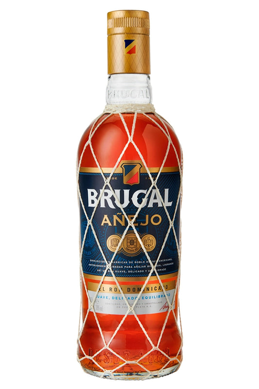 Botella de 70 cl de Ron Brugal Añejo, un ron dominicano añejado en barricas de bourbon. Sabor equilibrado y suave con notas de caramelo, especias suaves y madera. Color ámbar dorado. Ideal para mezclar o tomar solo. Presentado en botella de vidrio.