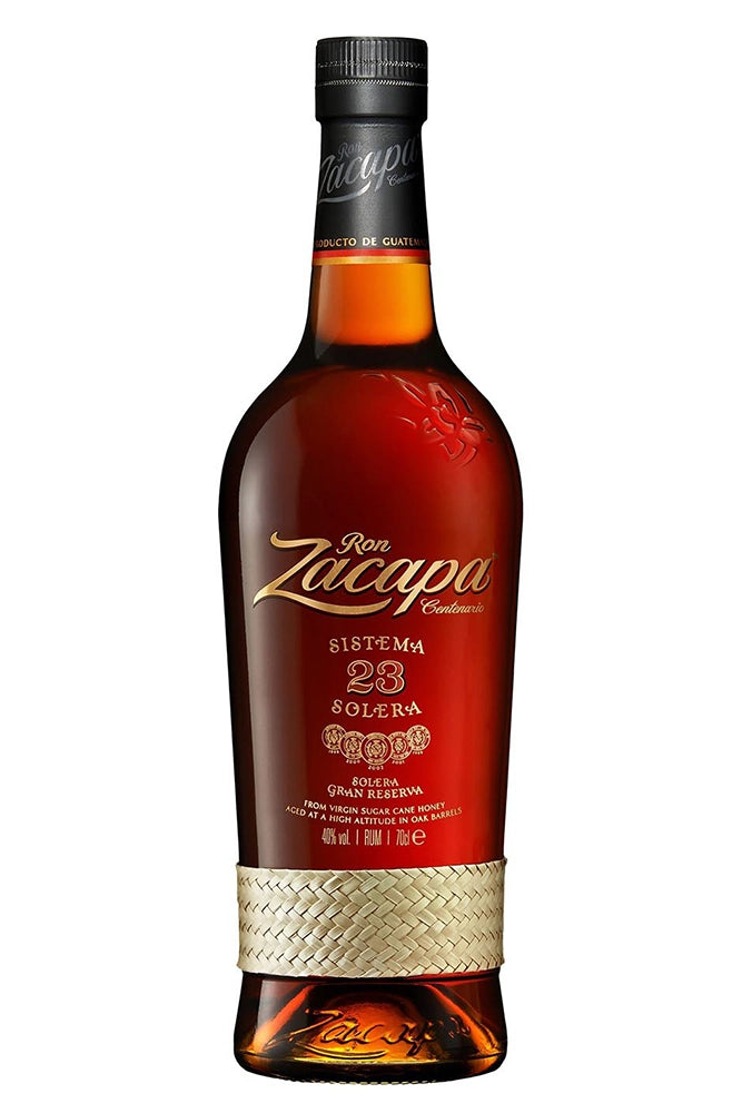 Botella de 70 cl de Ron Zacapa Centenario 23, un ron premium guatemalteco elaborado con miel virgen de caña de azúcar y añejado en barricas de roble blanco. Proceso de crianza en 3 etapas: bourbon americano, Jerez y vino de Málaga. Color caoba claro, aroma a caramelo tostado y almendras. Sabor potente, elegante y dulce. Presentado en botella de vidrio con etiqueta distintiva.