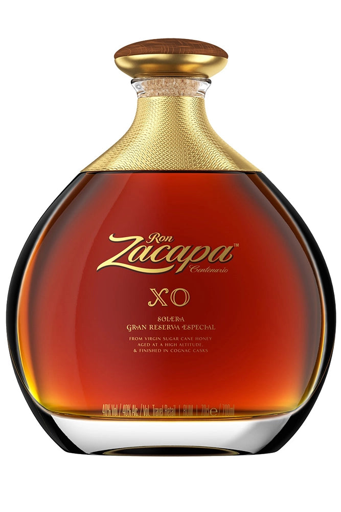 Botella de 70 cl de Ron Zacapa XO, un ron ultra premium guatemalteco envejecido en barricas de coñac. Color ámbar intenso, aroma a frutas secas, vainilla, madera tostada y chocolate oscuro. Sabor complejo, redondo, elegante y con final largo y suave. Presentado en botella de vidrio con etiqueta distintiva.