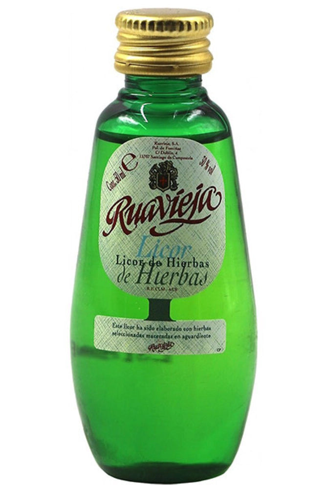 Mini botella Hierbas Ruavieja 5 cl, licor herbal dorado brillante.